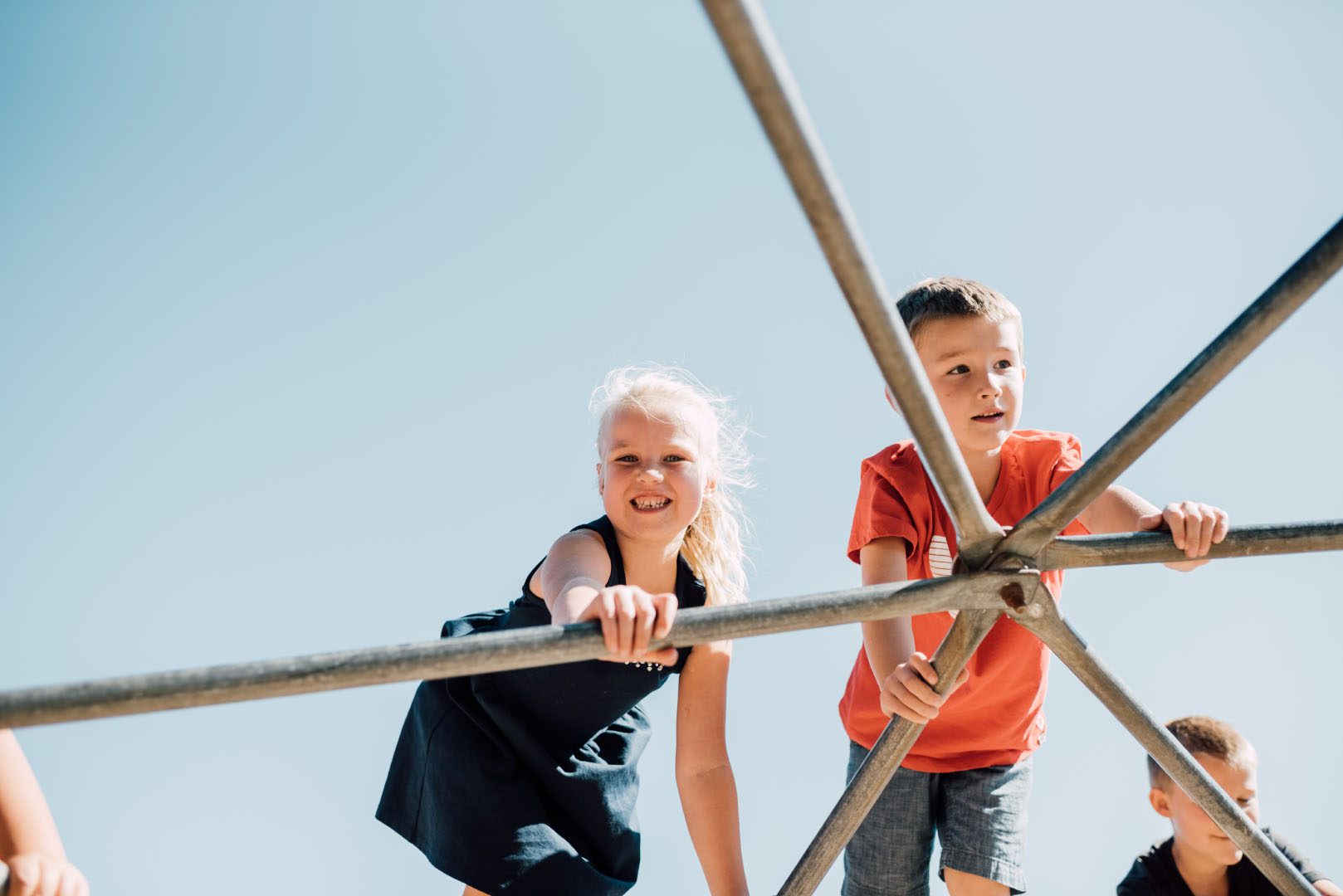 Two ACS elementary students climb the jungle gym
